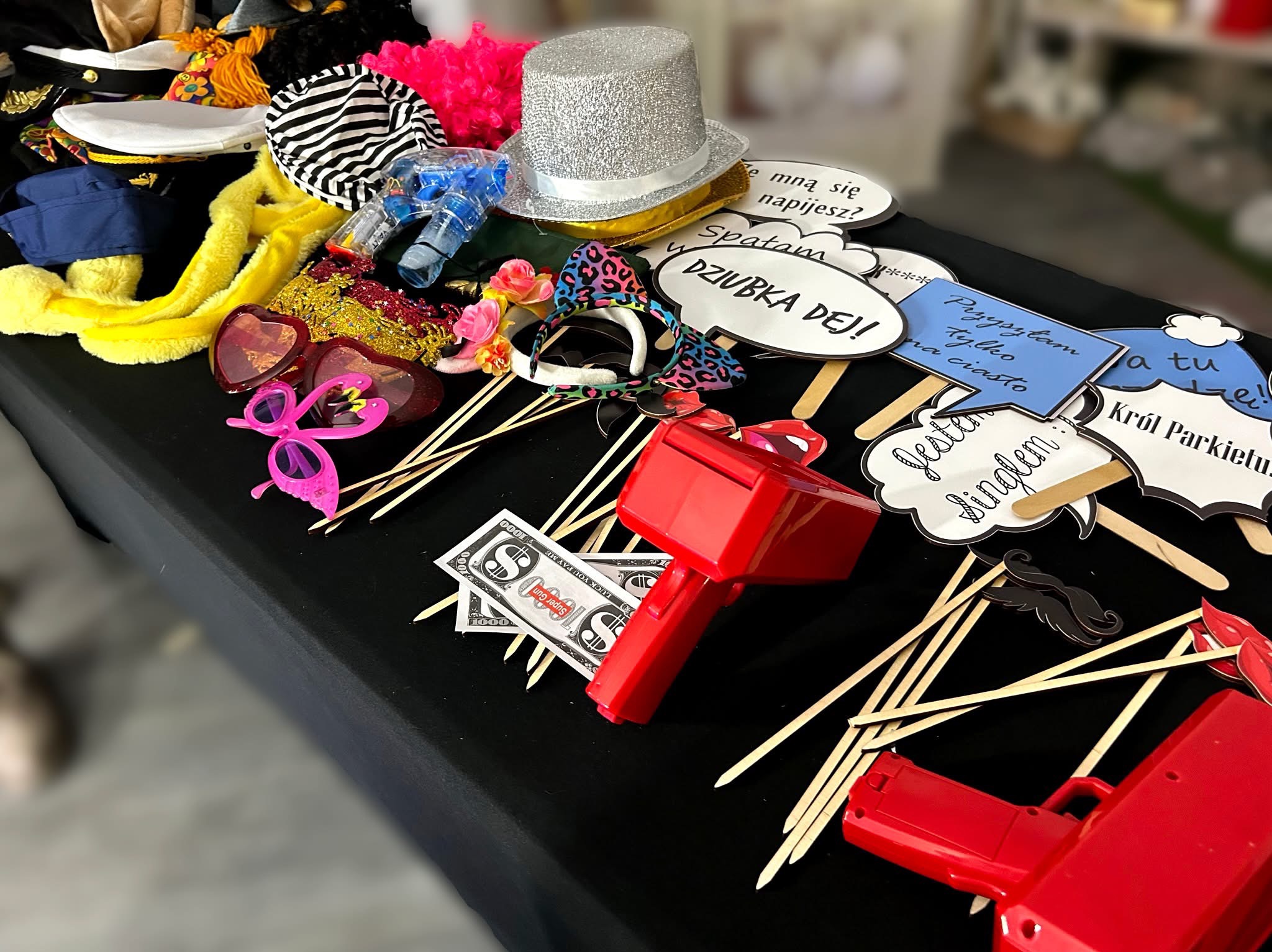 Akcesoria do fotobudki w Warszawie: zabawne rekwizyty, okulary, kapelusze, peruki i gadżety na patyku, gotowe do urozmaicenia zdjęć podczas imprezy.