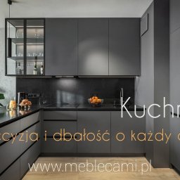Pracownia mebli Cami - Nowoczesna, szara kuchnia z czarnym blatem i oświetleniem LED. Szklana witryna z dekoracyjnymi butelkami. Minimalistyczny design z rośliną doniczkową na blacie.