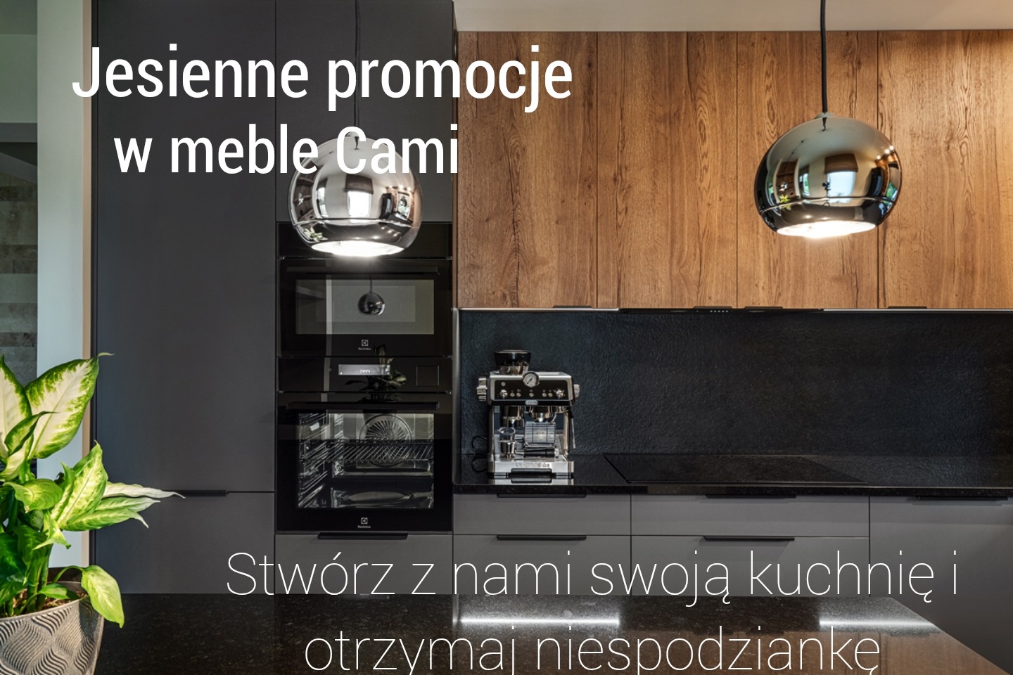 Nowoczesna kuchnia w odcieniach szarości z drewnianymi akcentami, oświetlona kulistymi lampami. Na blacie ekspres do kawy. Widoczna zieleń rośliny doniczkowej.