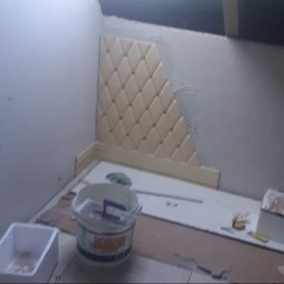 DUM - BUD ANDRZEJ DUMANOWSKI - Montaż dekoracyjnych paneli ściennych w romby, widoczny klej i narzędzia glazurnicze. Prace wykończeniowe w pomieszczeniu ze skosem.