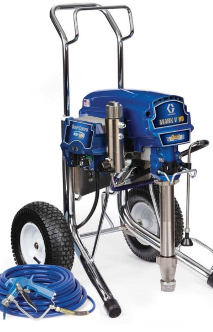 Profesjonalny agregat malarski Graco Mark V HD z wężem i pistoletem natryskowym, na kółkach, w kolorze niebieskim i srebrnym, na białym tle.
