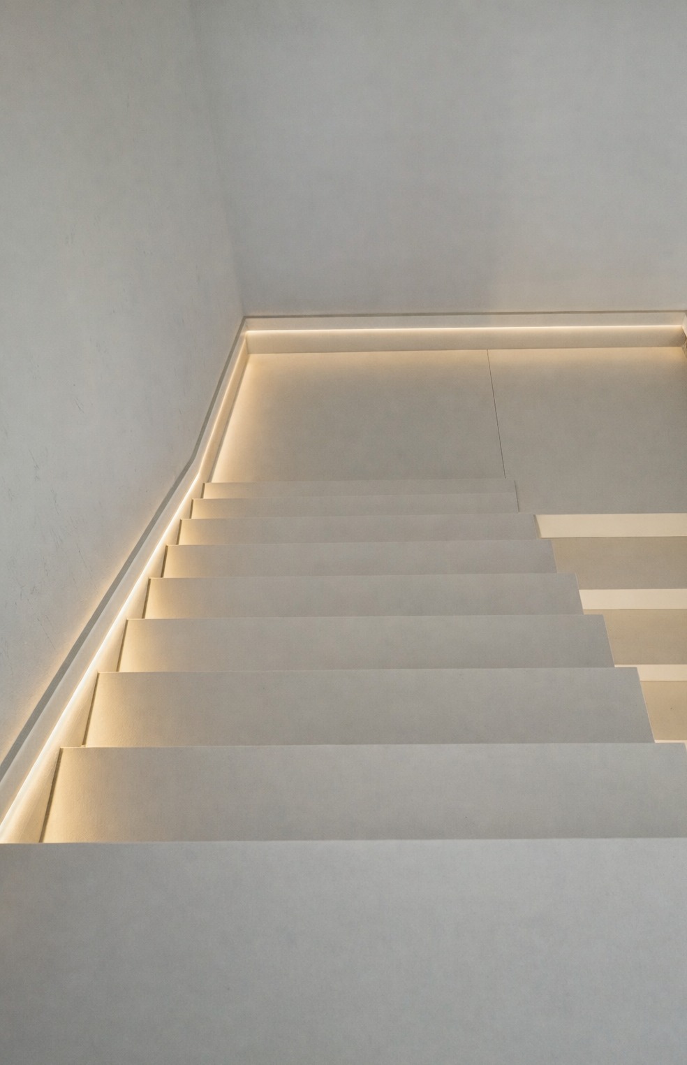 Minimalistyczne schody kamienne z subtelnym oświetleniem LED, widok z góry, podkreślający nowoczesny design i precyzję wykonania.