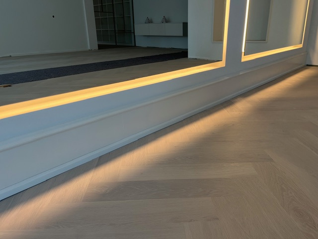 Parkiet ułożony w jodełkę francuską, listwy przypodłogowe z oświetleniem LED. Nowoczesne wykończenie wnętrza z dbałością o detale i precyzją wykonania.