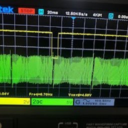 Evo Tune Oborniki Śląskie - Oscyloskop Hantek z wyświetlonymi przebiegami sygnałów elektrycznych w kolorach żółtym i zielonym. Widoczne parametry pomiarowe na ekranie urządzenia.