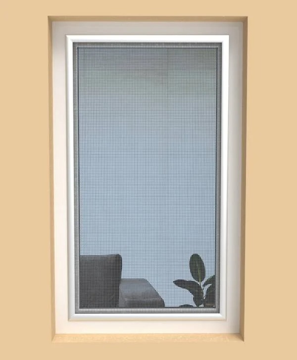 Zamontowana moskitiera w oknie z białymi ramami, widok na wnętrze z szarą sofą i rośliną. Delikatna siatka moskitiery zapewnia ochronę przed owadami.