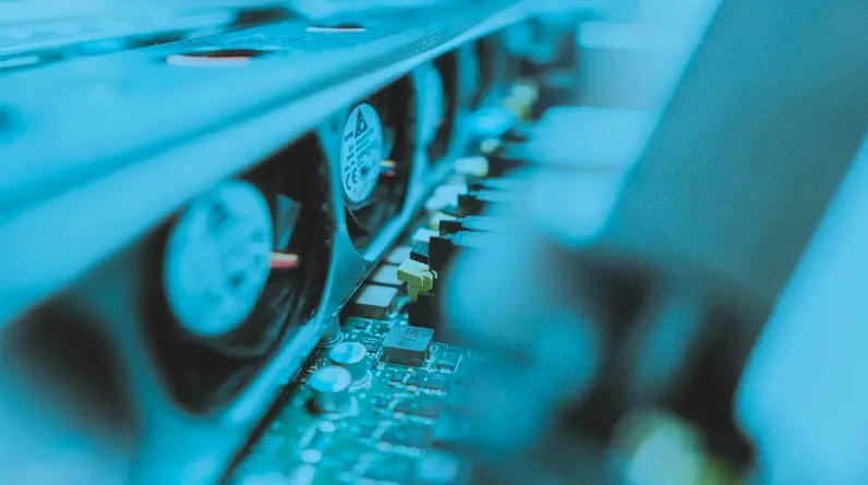 Wnętrze serwera z widocznymi wentylatorami chłodzącymi i płytą główną, oświetlone chłodnym, niebieskim światłem. Detaliczne ujęcie elektroniki.