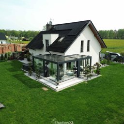 Nowoczesna weranda QubeXL w zabudowie narożnej L – elegancka strefa relaksu z ukrytym odwodnieniem i szklanym dachem na cały rok.