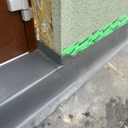 PRO DACHY - Hydroizolacje - Szczegółowe ujęcie hydroizolacji przy drzwiach, z widoczną taśmą uszczelniającą Siga Rissan i pianką montażową. Nowoczesne rozwiązanie dla szczelności budynku.