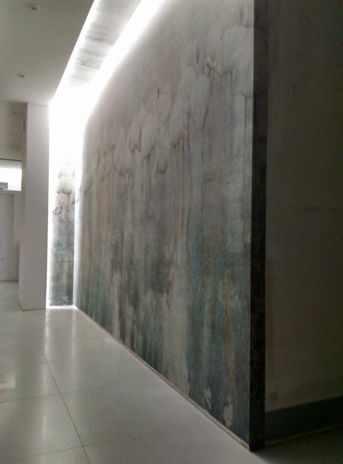 Abstrakcyjna dekoracja ściany w korytarzu z podświetleniem sufitowym. Szara podłoga z płytek. Artystyczne wykończenie wnętrza z efektem przenikania kolorów.