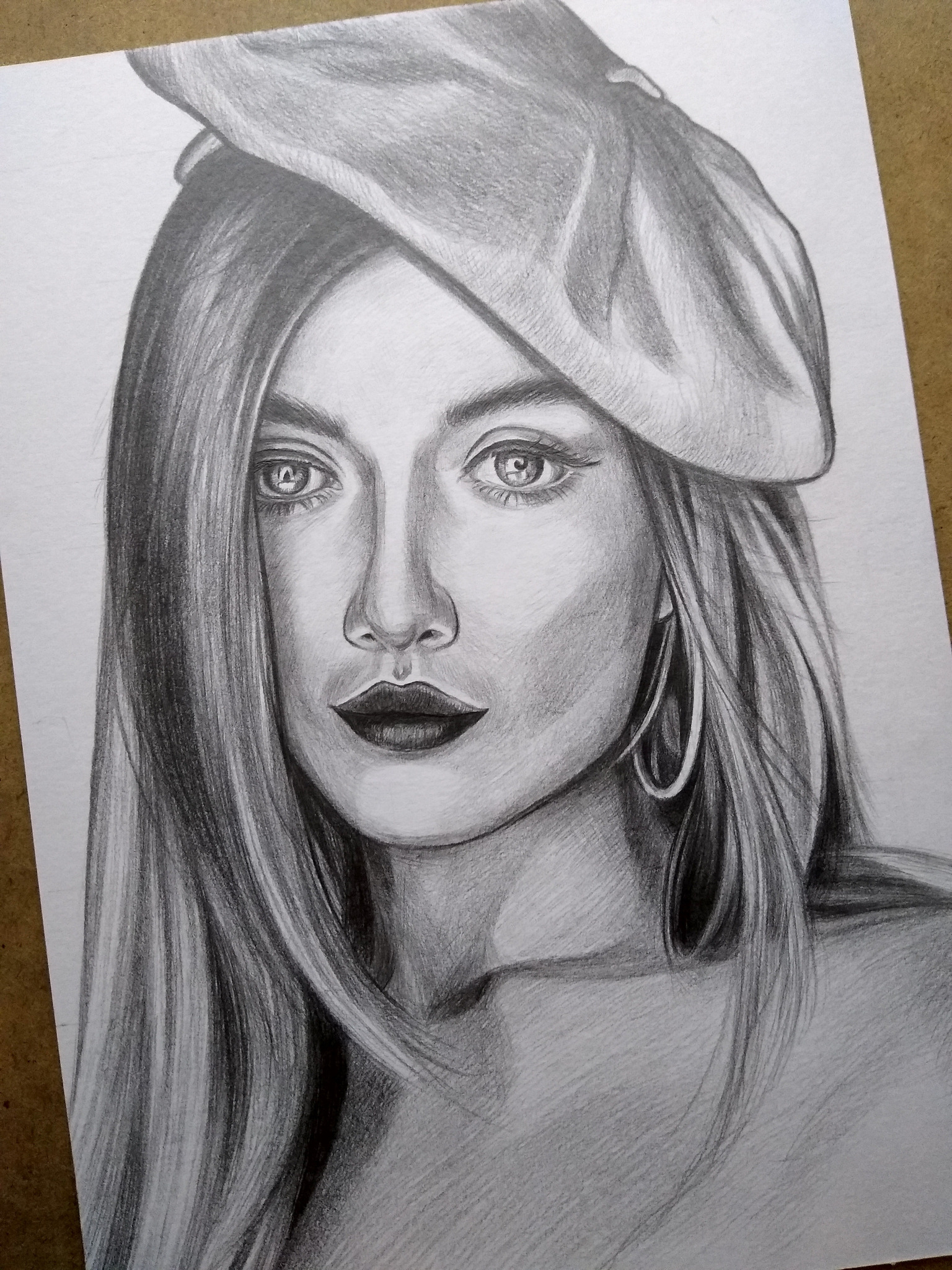 Realistyczny portret kobiety w berecie, wykonany ołówkiem. Detaliczne cieniowanie, skupienie na wyrazie oczu i ust. Klasyczny styl, widoczna faktura papieru.