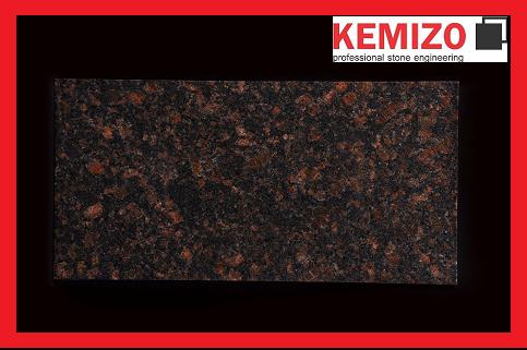 Płytka granitowa Tan Brown o wymiarach 30,5x61x1 cm, prezentowana na ciemnym tle z widocznym logo producenta KEMIZO w prawym górnym rogu.
