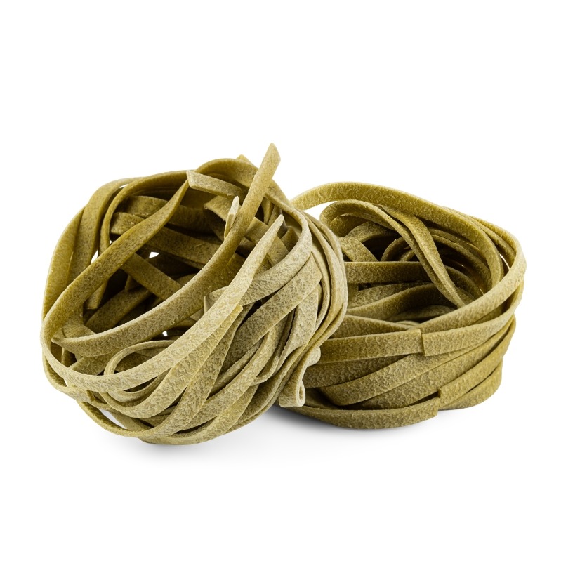 Dwa gniazda zielonego makaronu tagliatelle na białym tle, oświetlone z góry, ukazujące teksturę i kształt.