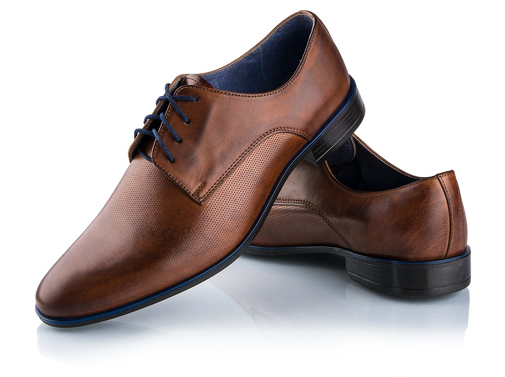 Brązowe, skórzane buty męskie typu oxford z niebieskimi sznurówkami i wykończeniem, ustawione pod kątem na białym, błyszczącym tle. Widoczne detale perforacji i faktury skóry.