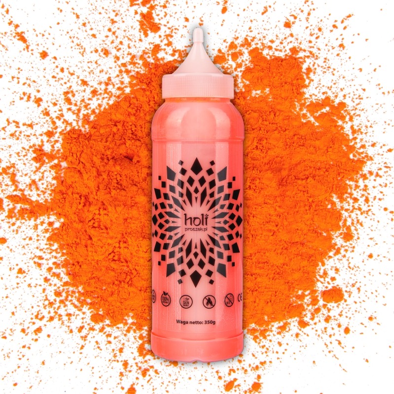 Różowa butelka z proszkiem Holi na tle rozsypanego pomarańczowego proszku. Produkt na białym tle, widoczne logo i informacje o wadze. Fotografia produktowa.