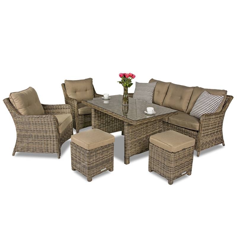 Komplet mebli ogrodowych z rattanu: sofa, dwa fotele, dwa pufy i stół z szklanym blatem. Na stole wazon z różowymi różami i dwie białe filiżanki.