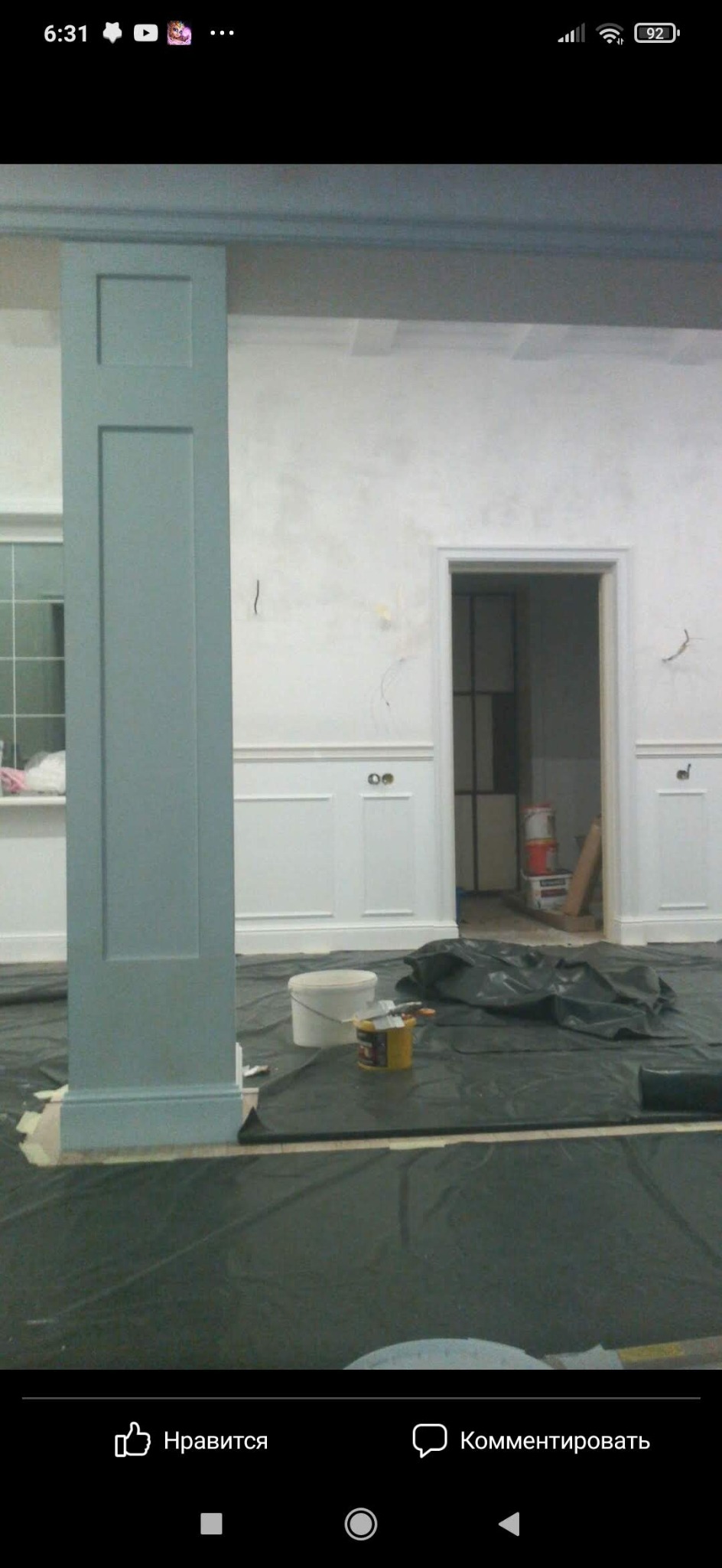 Malowanie kolumny w odcieniach szarości w pomieszczeniu z białymi panelami ściennymi. Widoczne narzędzia malarskie i zabezpieczenia podłogi.