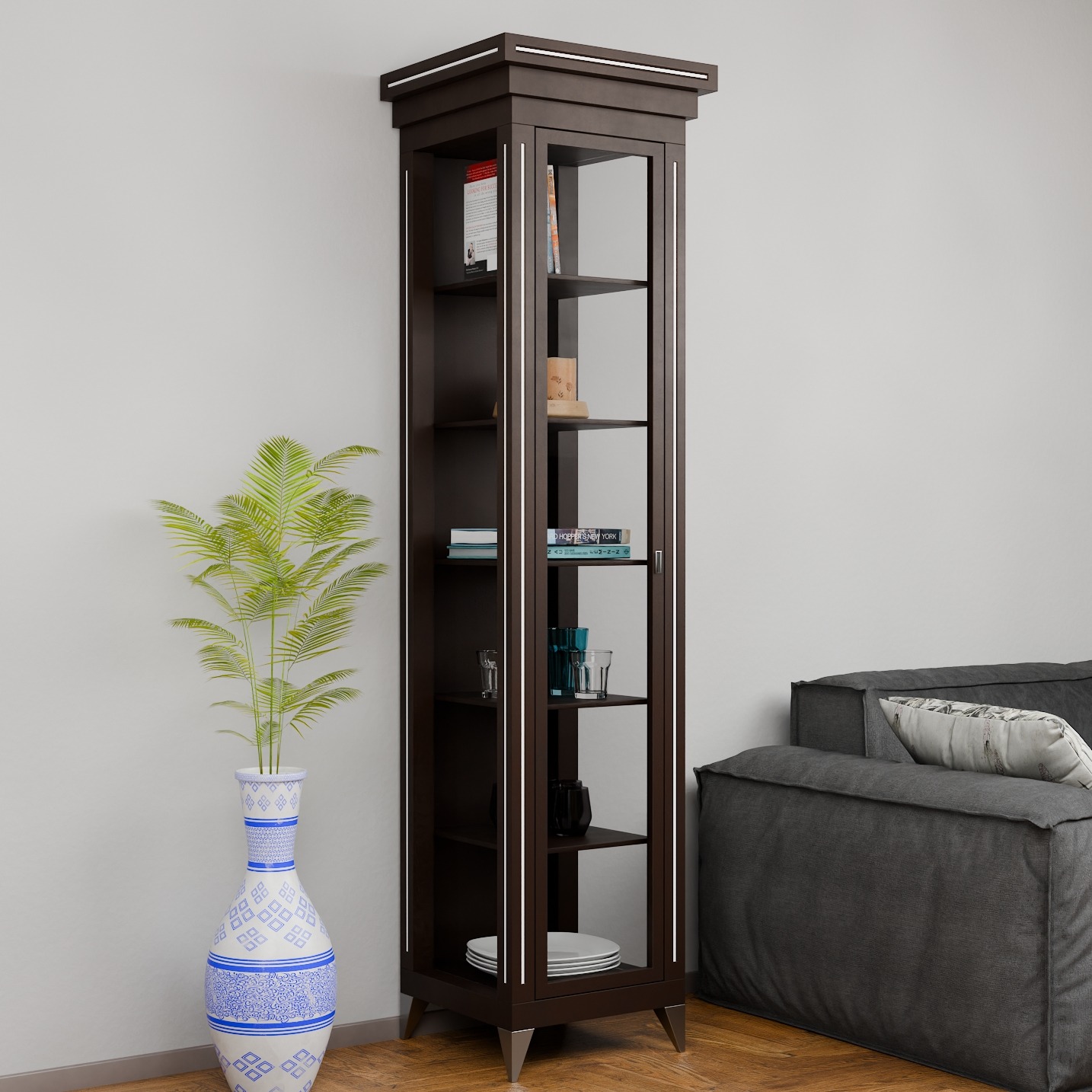Wysoka, smukła witryna wenge z przeszkleniami, oświetleniem LED i metalowymi nóżkami, stojąca obok wazonu z rośliną i szarej sofy w nowoczesnym salonie.