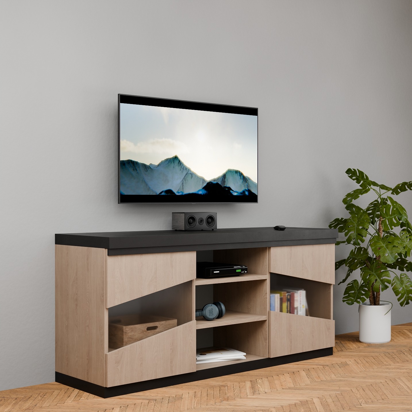 Nowoczesna szafka RTV z jasnego drewna i czarnym blatem, z otwartymi półkami na sprzęt i dekoracje. Na ścianie telewizor, obok roślina doniczkowa.