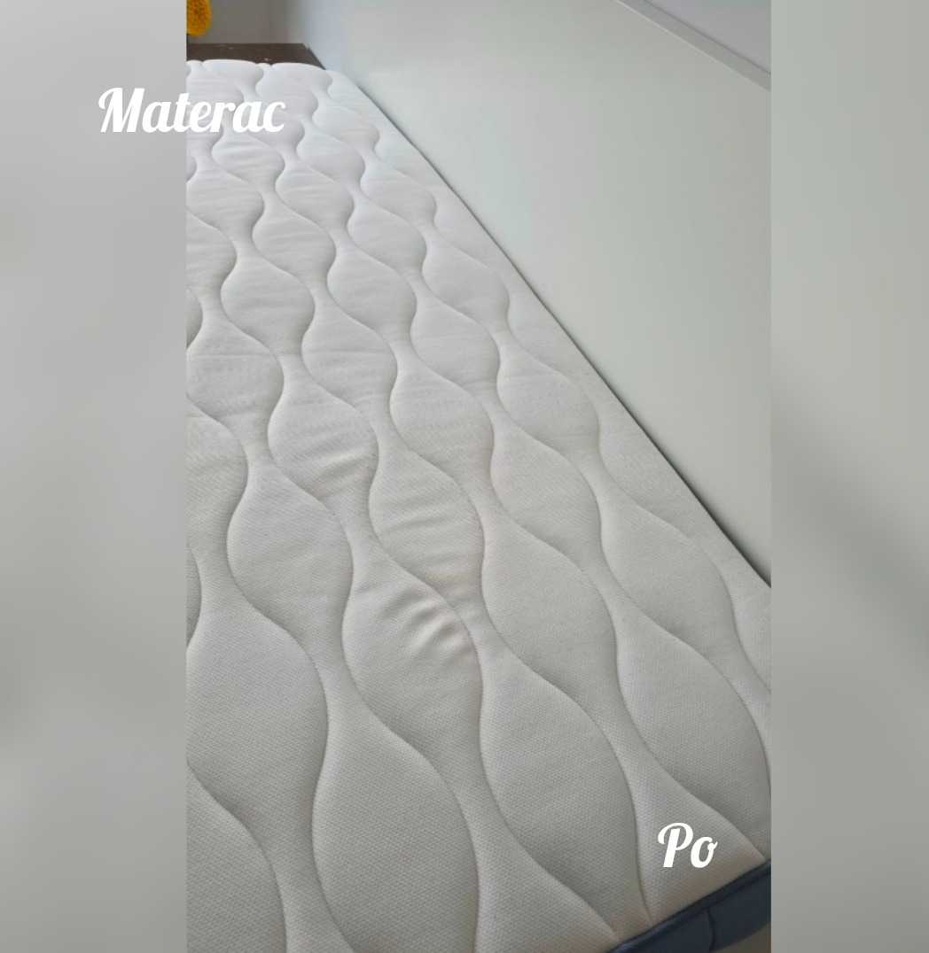 Czysty, biały materac po praniu, widoczne regularne wzory pikowania. Zdjęcie z bliska, ukazujące świeżość i higienę materaca.