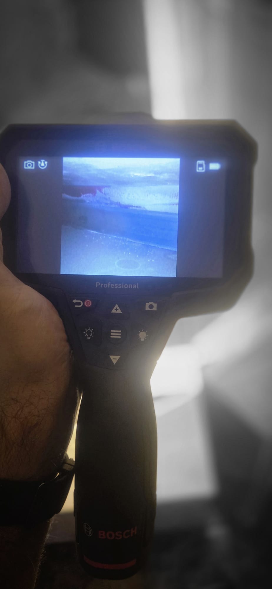 Termowizja w dłoni, ekran pokazuje obraz z kamery termowizyjnej. Narzędzie diagnostyczne Bosch Professional do wykrywania problemów hydraulicznych.