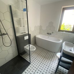 Sylwester Szulga - Nowoczesna łazienka po remoncie: biała wanna wolnostojąca, kabina prysznicowa typu walk-in, umywalka nablatowa i heksagonalne płytki na ścianach.