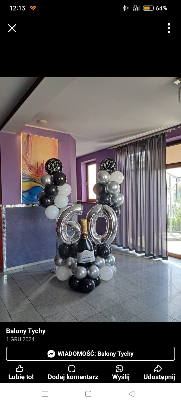 Dekoracja balonowa na 60. urodziny: srebrne cyfry, czarno-białe balony, butelka szampana. Kompozycja na tle fioletowej ściany i szarych zasłon.