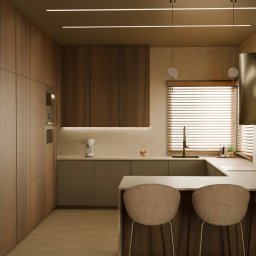 Nowoczesna kuchnia z drewnianymi szafkami, wyspą i hokerami. Oświetlenie liniowe LED i żaluzje w oknach dodają elegancji. Widoczny ekspres do kawy i drobne dekoracje.