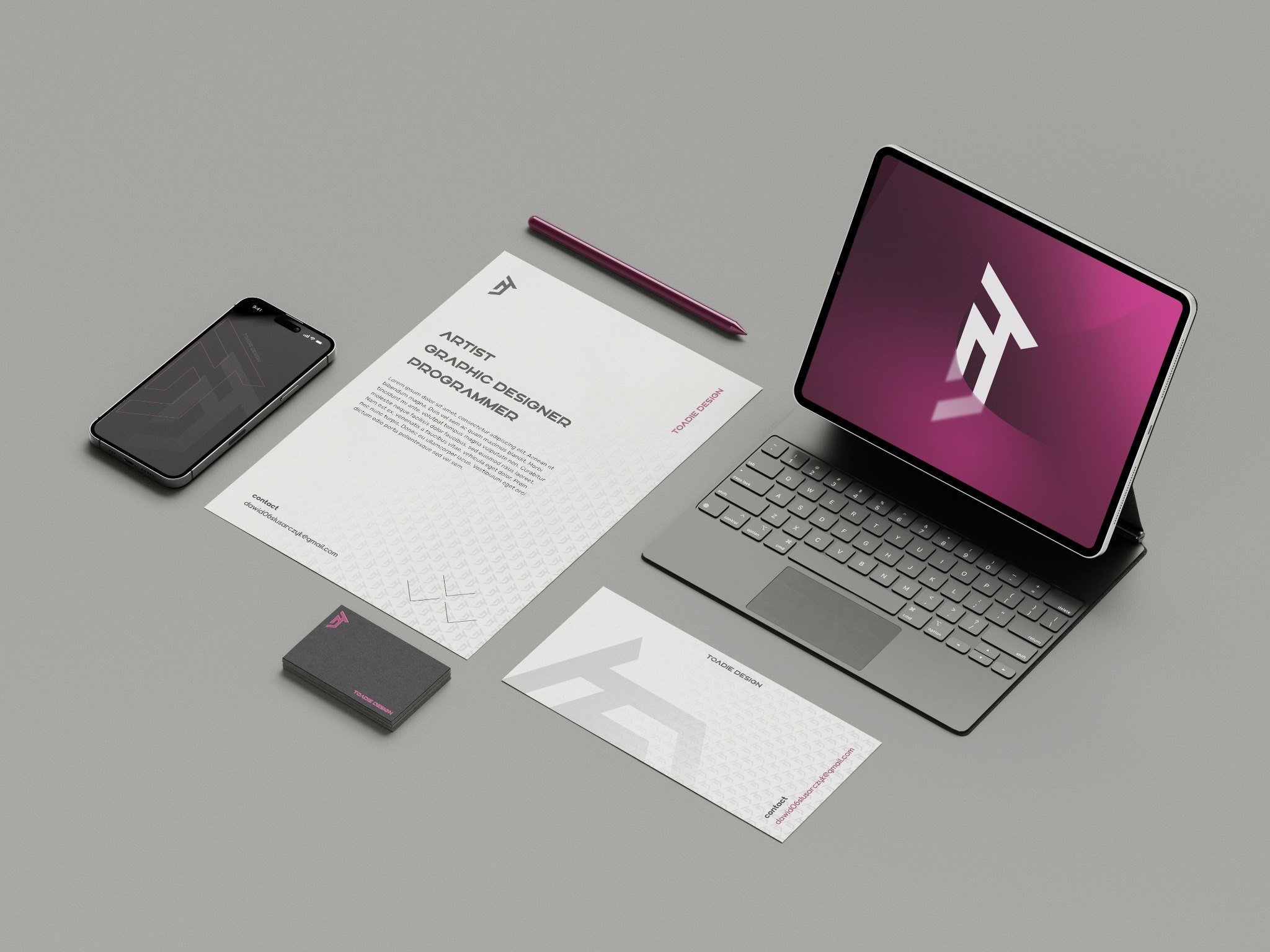 Mockup identyfikacji wizualnej: wizytówki, list firmowy, tablet i smartfon z logo 'Toadie Design' na szarym tle. Minimalistyczny design, nowoczesny branding.