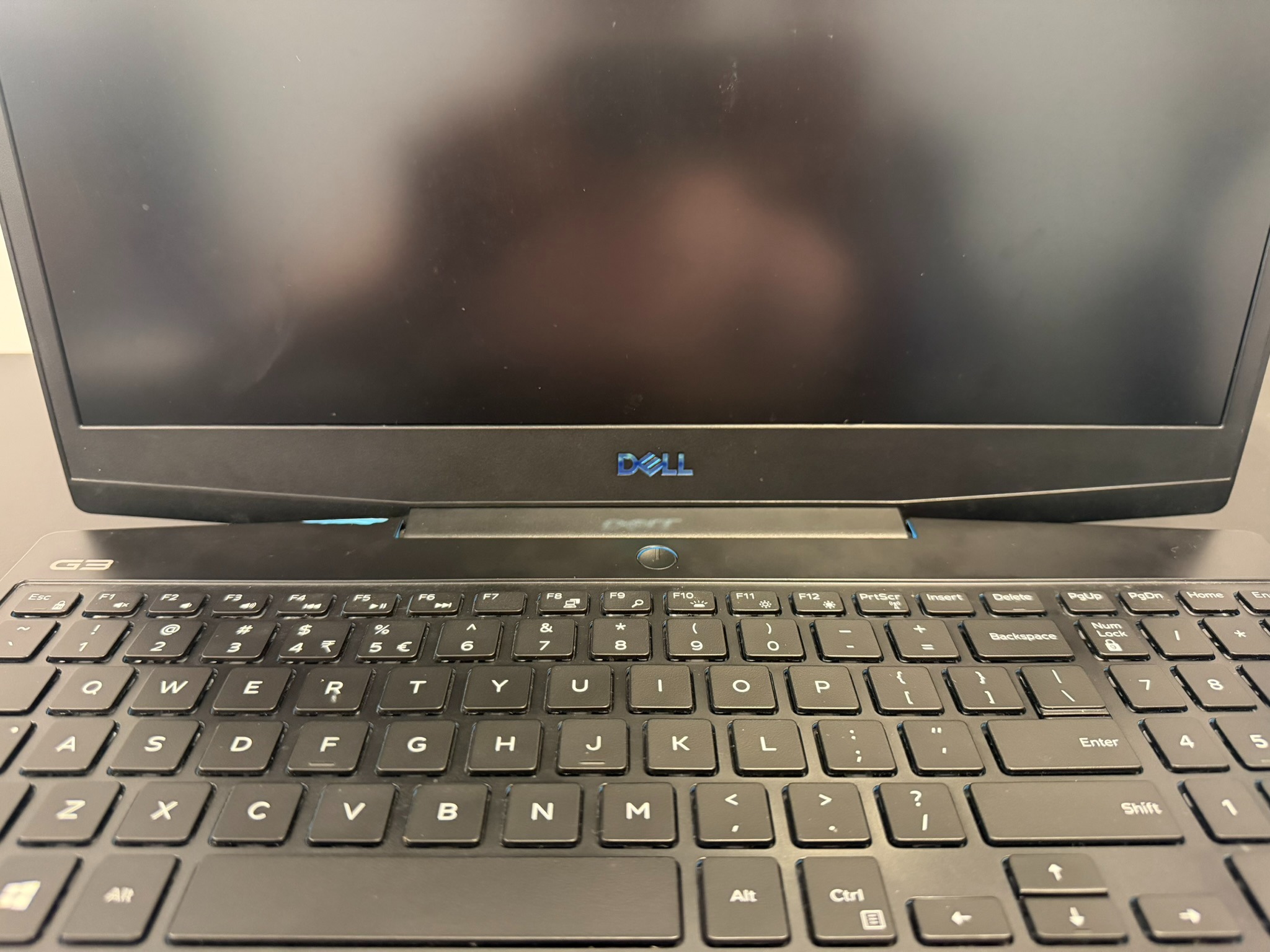 Czarny laptop Dell G3 z widoczną klawiaturą i podświetlanym logo. Ekran wyłączony, widoczne odciski palców. Sprzęt gotowy do naprawy lub odzyskiwania danych.