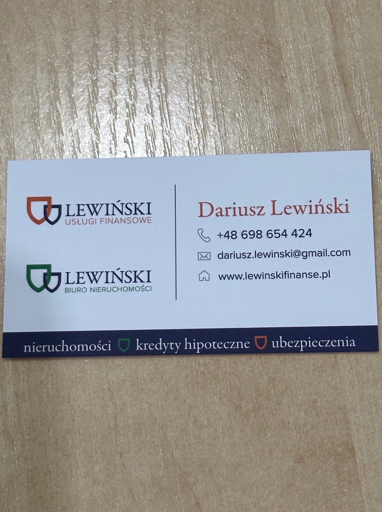 Wizytówka Dariusza Lewińskiego z usługami finansowymi i biurem nieruchomości, z numerem telefonu, adresem e-mail i stroną internetową na jasnym tle.