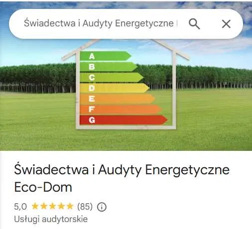 Graficzne przedstawienie klasy energetycznej budynku na tle krajobrazu, z zaznaczonymi poziomami od A do G w formie kolorowych strzałek.