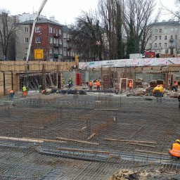 PAROTECH SPÓŁKA Z OGRANICZONĄ ODPOWIEDZIALNOŚCIĄ - Zbrojenie fundamentów pod budowę w Halinowie. Widoczne liczne pręty zbrojeniowe tworzące siatkę, pracownicy w odblaskowych kamizelkach i szalunki.