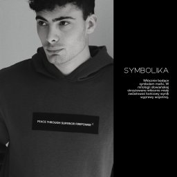 33 STUDIO Design - Męski model prezentuje bluzę z kapturem i napisem 'PEACE THROUGH SUPERIOR FIREPOWER X'. Obok tekst 'SYMBOLIKA' i opis włóczni jako symbolu marki. Portfolio 2026.