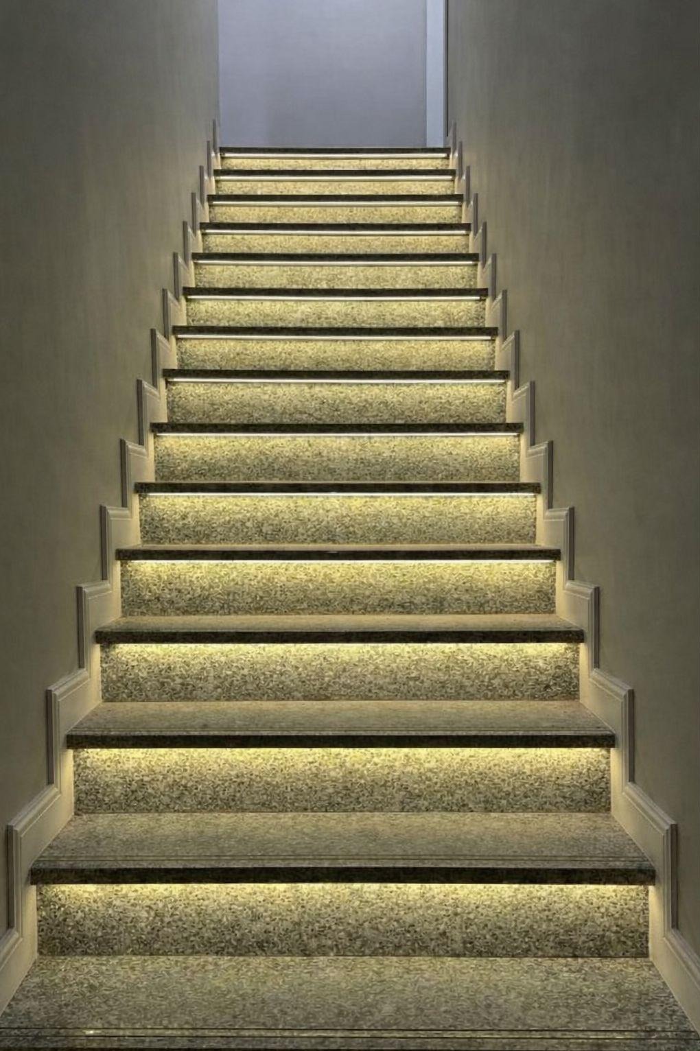 Schody z kamienia z subtelnym, ciepłym oświetleniem LED pod każdym stopniem, tworzącym elegancki i nowoczesny efekt wizualny. Minimalistyczny design.