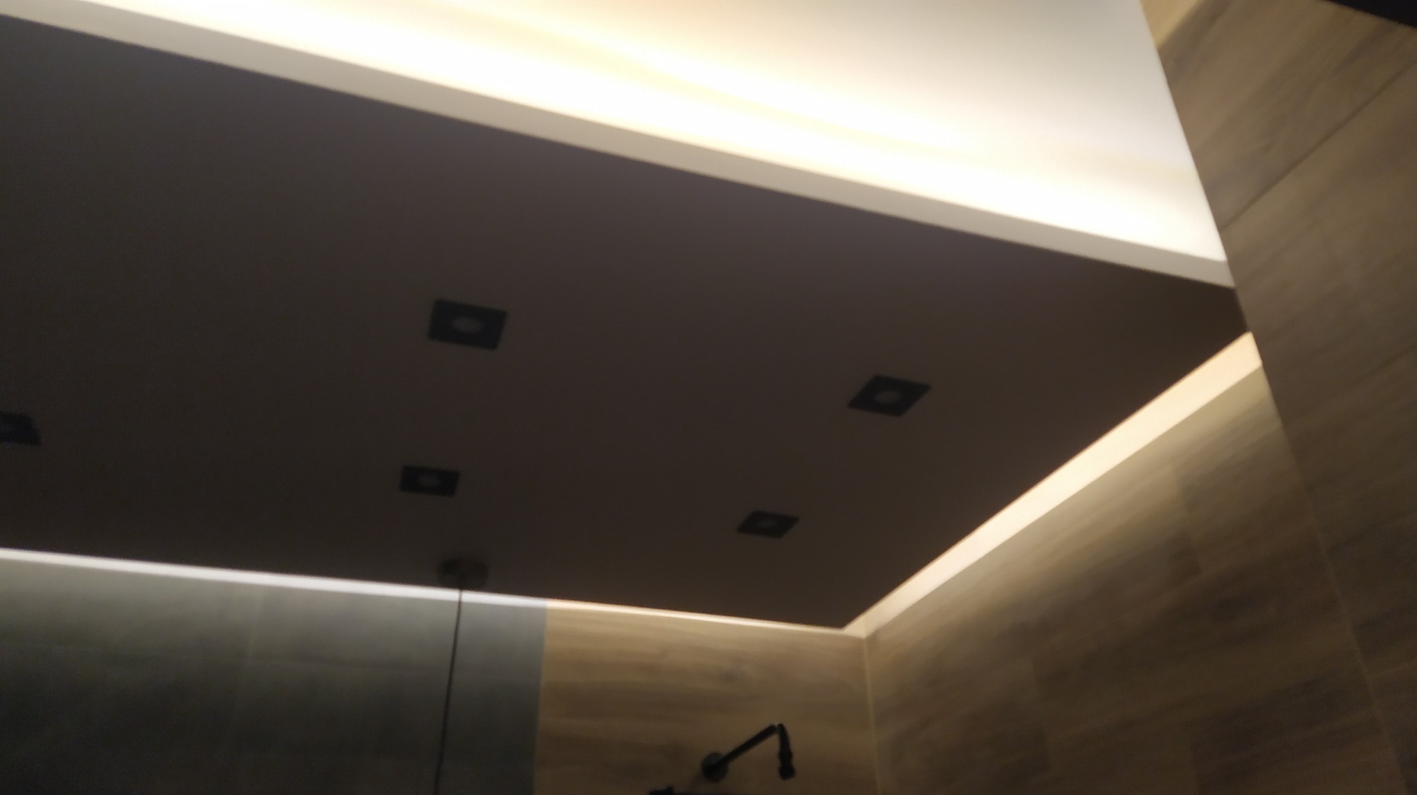 Podwieszany sufit z oświetleniem LED i czterema punktowymi lampami w łazience w Łyszkowicach, widok z dołu.
