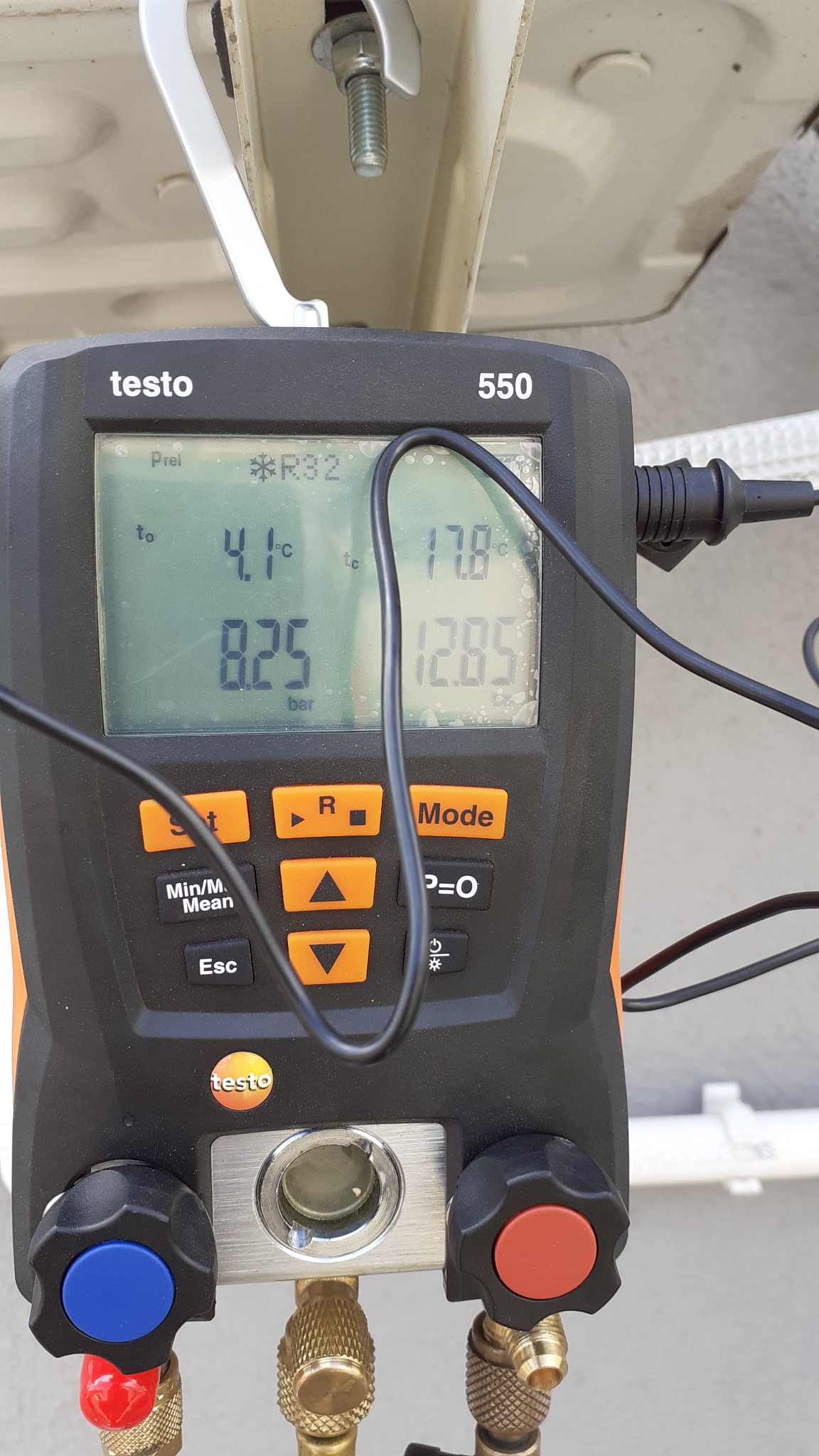 Miernik Testo 550 z wyświetlonymi parametrami pracy klimatyzacji, w tym ciśnienie i temperatura czynnika R32. Widoczne zawory i przewody pomiarowe.