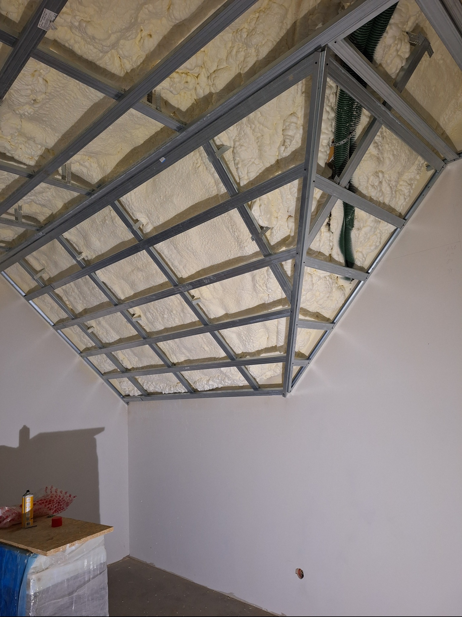 Ocieplenie poddasza pianą PUR w Skrzeszewie Żukowskim. Widoczna metalowa konstrukcja i nałożona piana izolacyjna. Izolacja natryskowa.