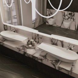 DNP Trading&Development Sp. z o.o. - Nowoczesna łazienka z marmurowym blatem, dwiema owalnymi umywalkami i minimalistycznymi akcesoriami. W tle widoczne toaleta i bidet na marmurowej ścianie.