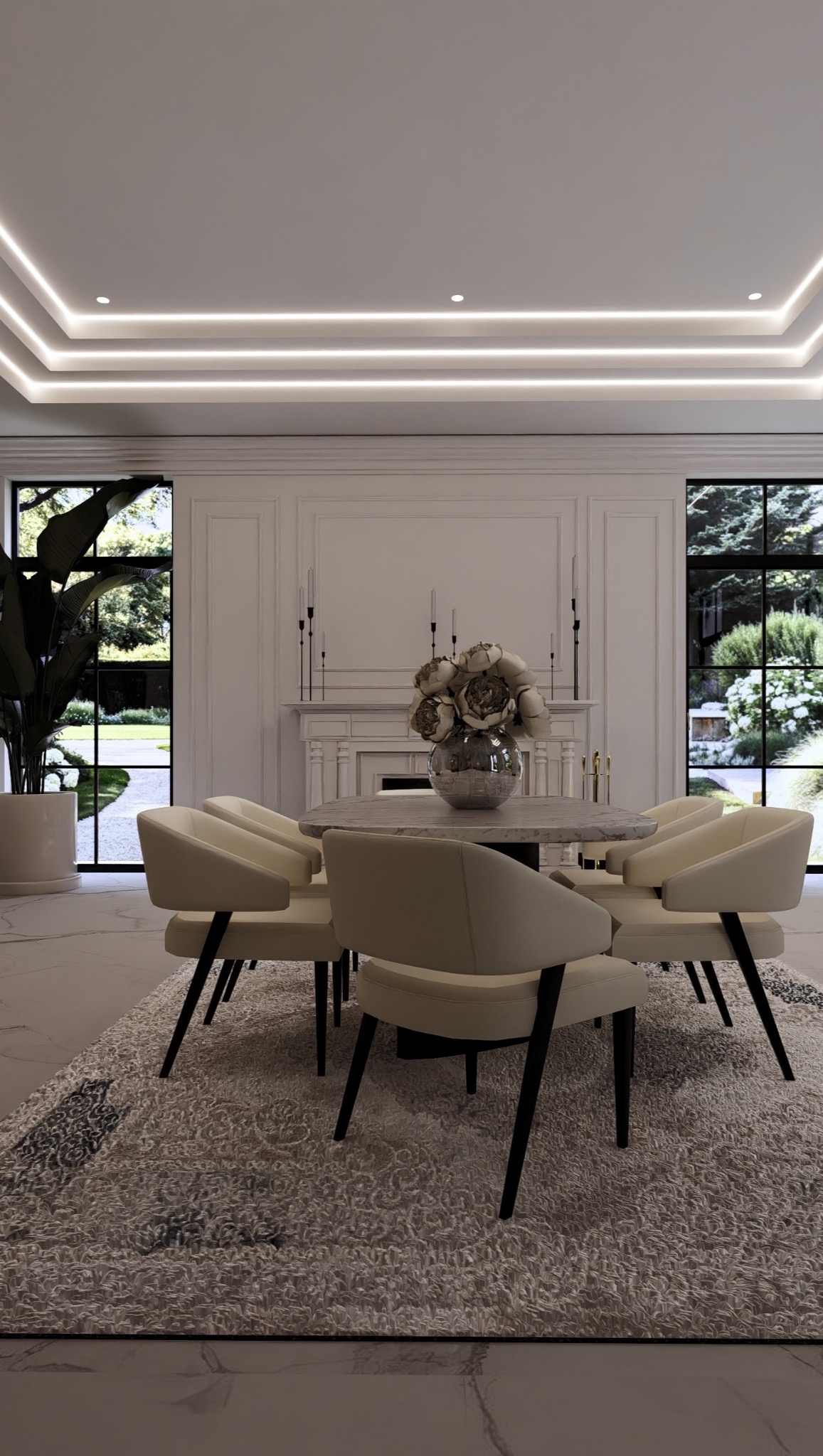 Elegancka jadalnia z okrągłym stołem, kremowymi krzesłami i dywanem w odcieniach szarości. W tle kominek i duże okna z widokiem na zieleń.