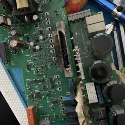 B&G Electronics - Uszkodzona płyta falownika z widocznymi elementami elektronicznymi, narzędzia obok. Detaliczne ujęcie podkreśla złożoność naprawy elektroniki przemysłowej.