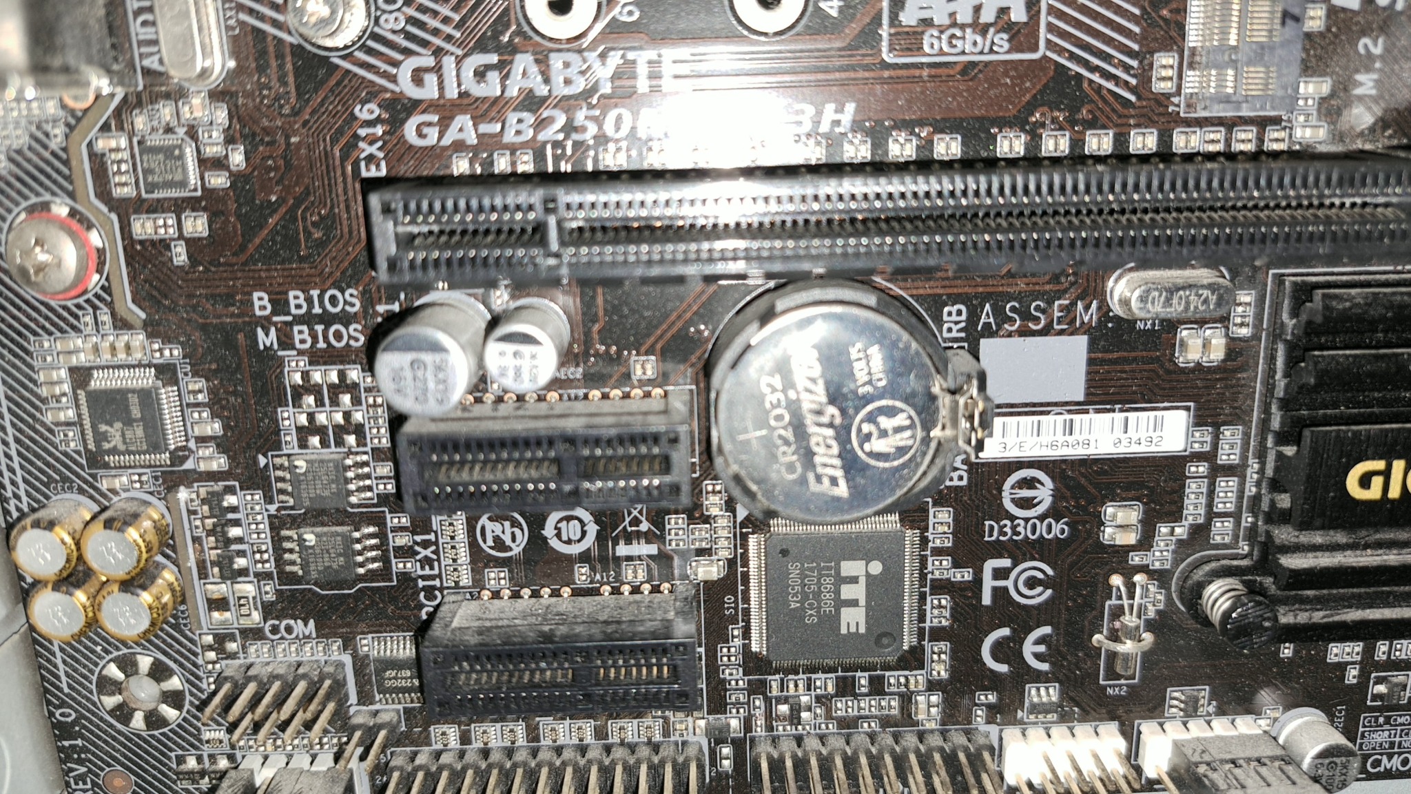 Płyta główna Gigabyte GA-B250N z widocznymi slotami, baterią BIOS i elementami elektronicznymi. Detaliczne ujęcie, podkreślające złożoność komponentów.