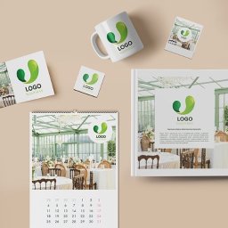 EMPIK FOTO SPÓŁKA Z OGRANICZONĄ ODPOWIEDZIALNOŚCIĄ - Zestaw materiałów reklamowych z identycznym logo: kalendarz, kubek, wizytówki, podkładka i folder, na beżowym tle. Prezentacja spójnej identyfikacji wizualnej firmy.