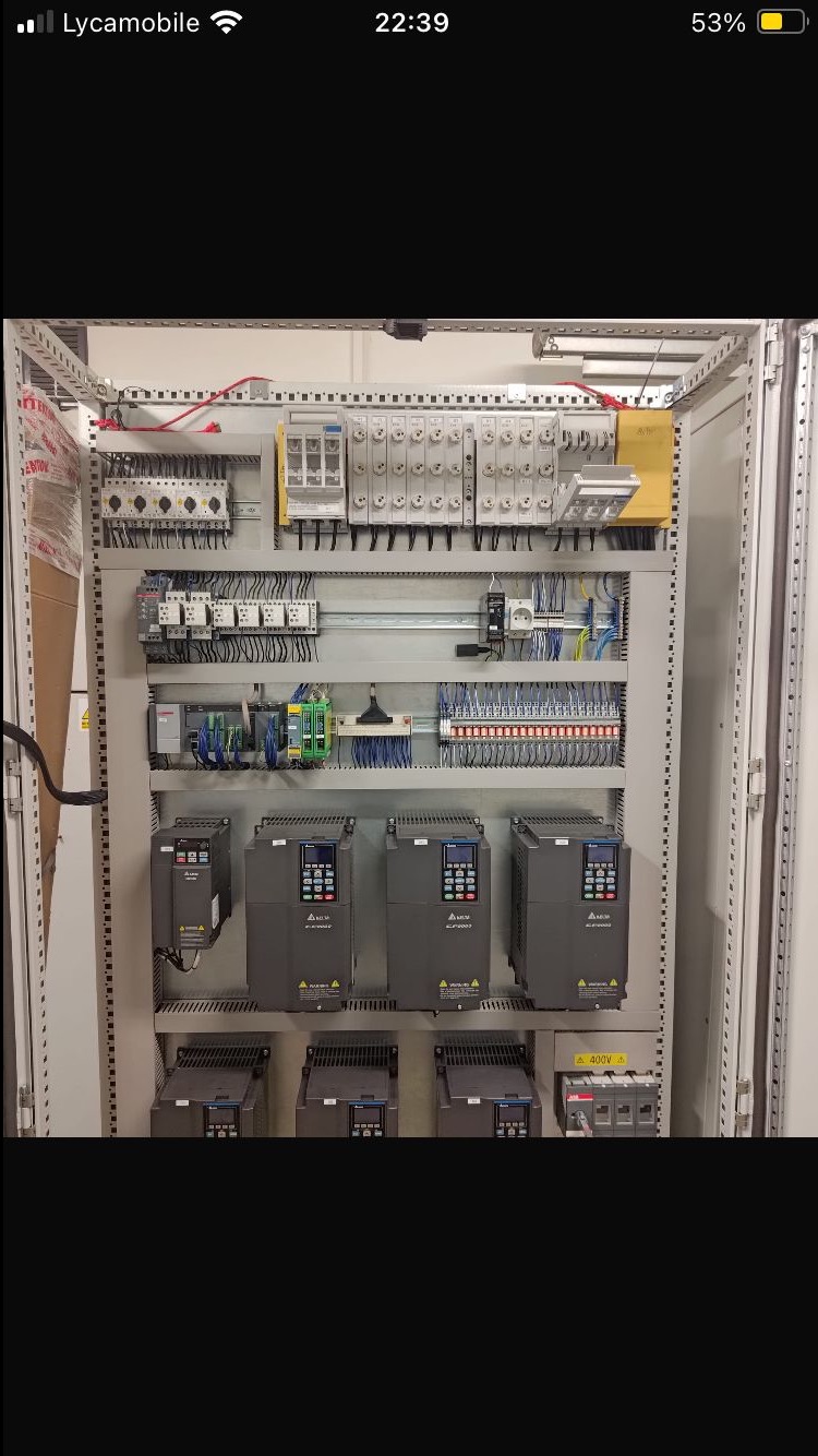 Rozdzielnica elektryczna z zamontowanymi elementami sterującymi i zabezpieczającymi, widoczne przewody i urządzenia Delta, całość w metalowej obudowie.