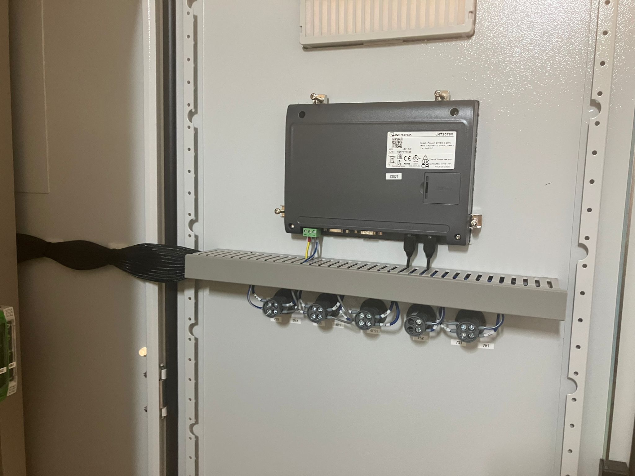 Szara szafa sterownicza z zamontowanym panelem sterującym Weintek cMT2078X i podłączonymi przewodami. Widoczne oznaczenia na złączach i etykieta z kodem QR.