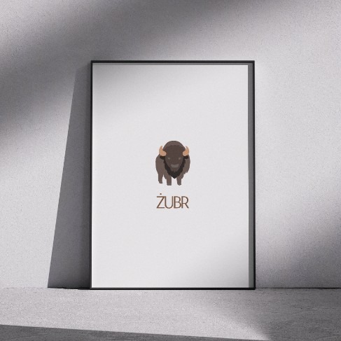 Ilustracja żubra w minimalistycznym stylu, umieszczona w czarnej ramce, oparta o szarą ścianę i podłogę. Pod ilustracją widnieje napis 'ŻUBR'.