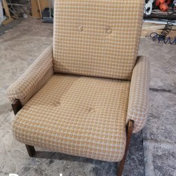Dar Pikowania Natalia Kokoszka - Kadr na fotel z żółto-białą tapicerką w drobną kratę, z drewnianymi nogami i podłokietnikami. Widoczny napis 'Przed', sugerujący stan przed renowacją.