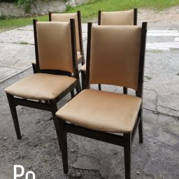 Dar Pikowania Natalia Kokoszka - Cztery krzesła po renowacji tapicerki, z beżowym obiciem i ciemnym drewnianym stelażem, ustawione na zewnątrz na betonowym podłożu z widoczną zielenią w tle.