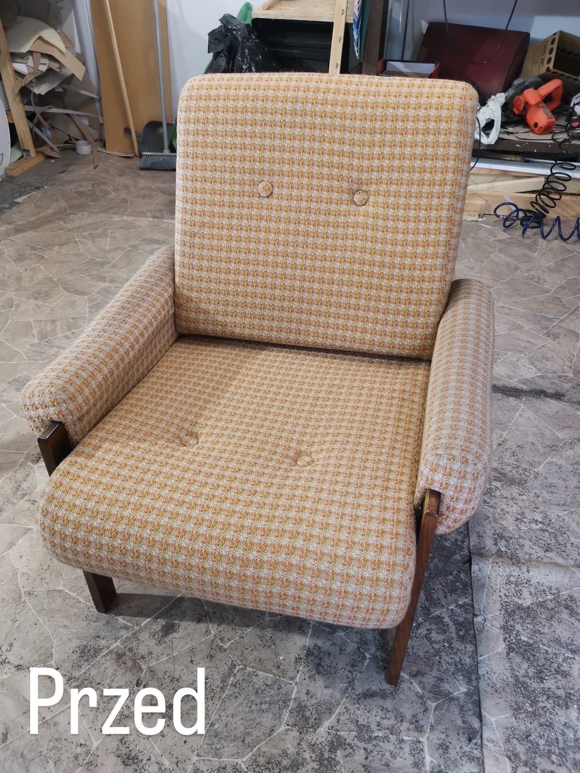 Kadr na fotel z żółto-białą tapicerką w drobną kratę, z drewnianymi nogami i podłokietnikami. Widoczny napis 'Przed', sugerujący stan przed renowacją.
