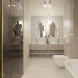 Dwa nieregularne lustra o organicznych kształtach przyciągają wzrok i wprowadzają artystyczny akcent, przełamując geometryczną prostotę przestrzeni. Złote wykończenia pięknie odbijają światło, potęgując wrażenie luksusu i ciepła.