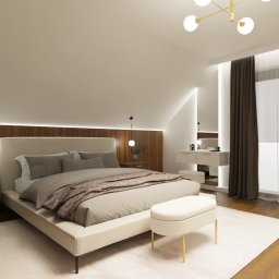 Centralnym punktem aranżacji jest ściana kolankowa za łóżkiem, wykończona na całej długości ciemniejszym pasem drewnopodobnej płyty meblowej. Faktura i głębia koloru wprowadzają do wnętrza ciepło oraz wyraźny akcent podkreślając architekturę poddasza.